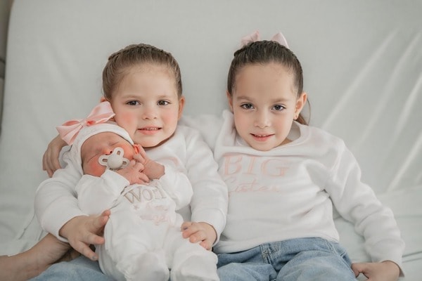 Hermanas mayores con bebe recien nacido